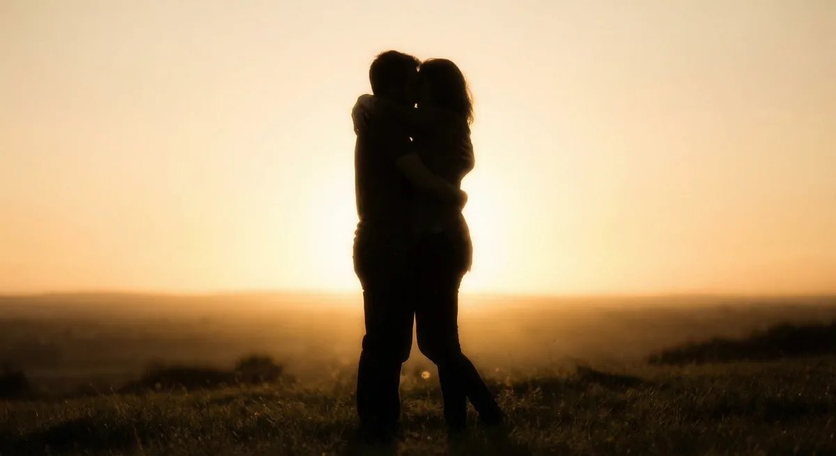 Two figures embracing in warm light